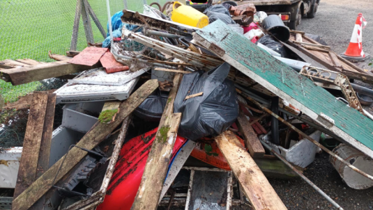 fly tip of various items including wood, windows and bins