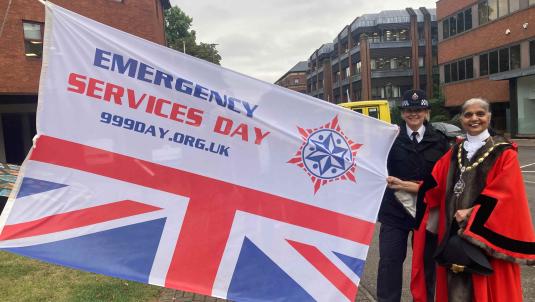 Mayor and Police Borough Commander holding Emergency Services Day flag