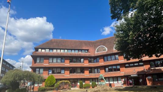 Side view of Surrey Heath House with blue sky and clouds 