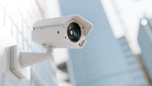 White CCTV camera on side of building