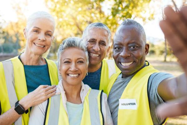 diverse group of people with high vis jackets in a park