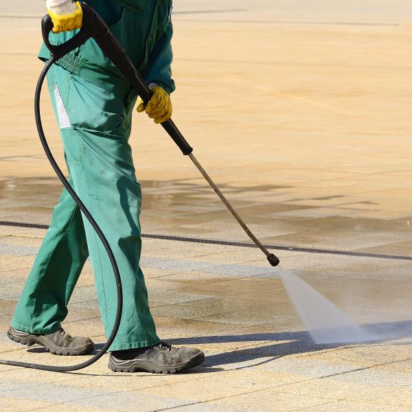 Street cleaner jet washing the pavement