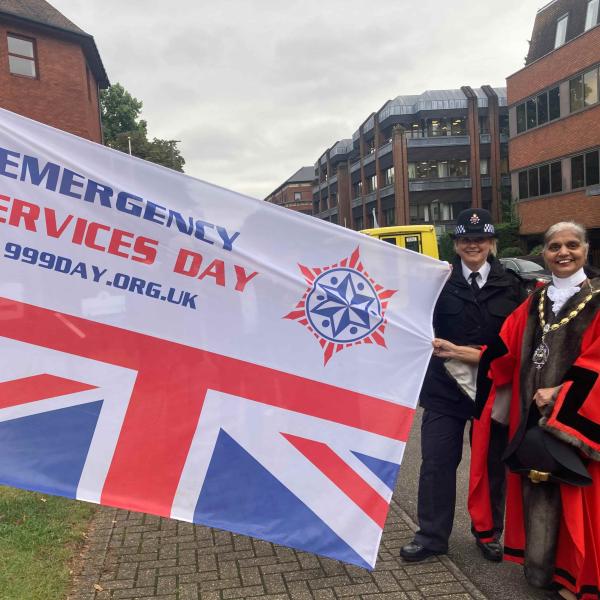 Mayor and Police Borough Commander holding Emergency Services Day flag