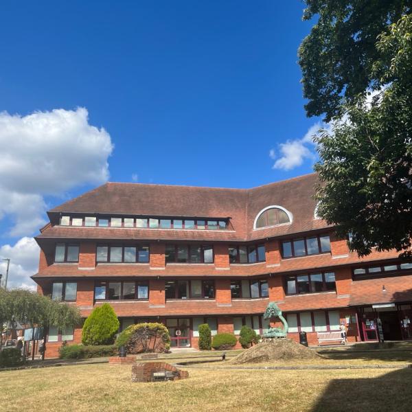 Side view of Surrey Heath House with blue sky and clouds 